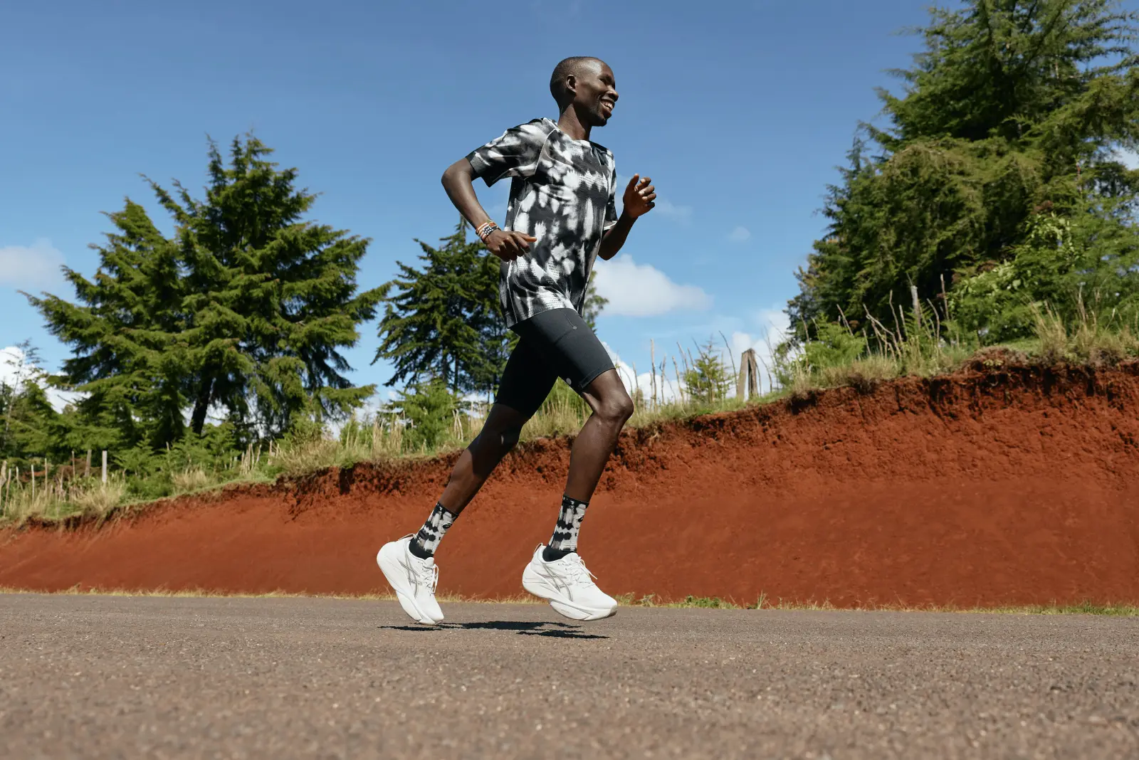 A runner in white ASICS Gel-Slowcush shoes striding along a roadside path