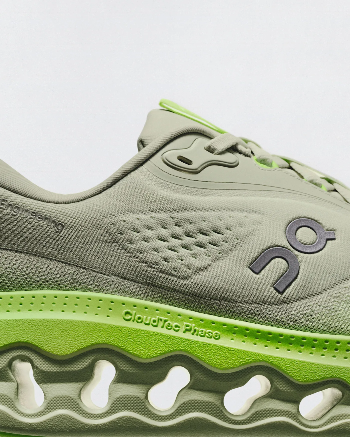 Close-up of the On Cloudsurfer 3 in sage green, showing the knit upper and the lime CloudTec Phase midsole with its cutouts