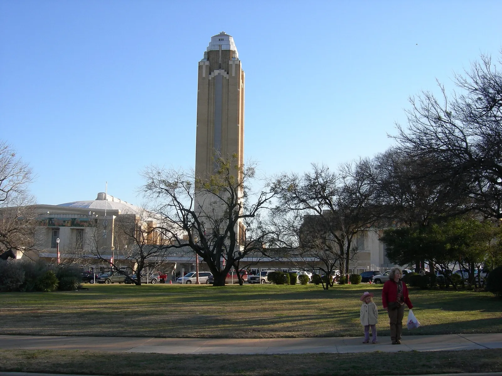 The tall Pioneer Tower of Will Rogers Memorial Center in Fort Worth rises behind bare trees and a lawn on a clear winter day